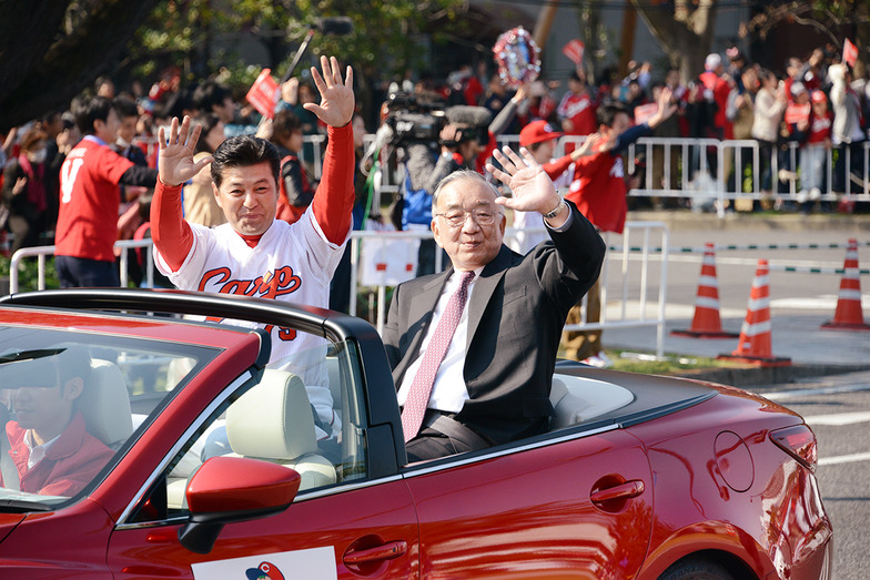 手を振る緒方孝市監督（左）と松田元オーナー（右）