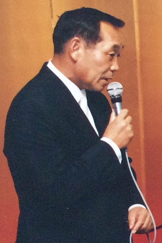 部下の結婚式でスピーチする阿部